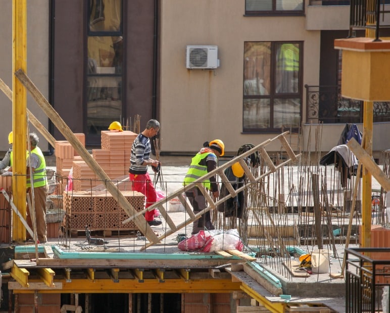 pomorie, bulgaria march 14, 2019: bricklayer preparing laying bricks on wall.